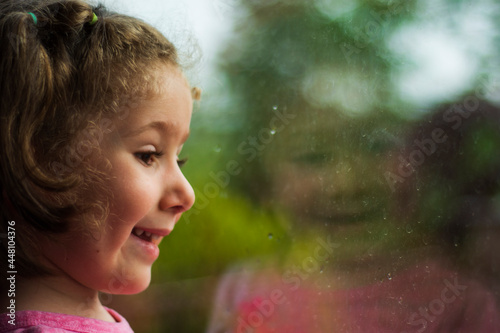 little girl looking out the window of her house. Selective Focus girl.