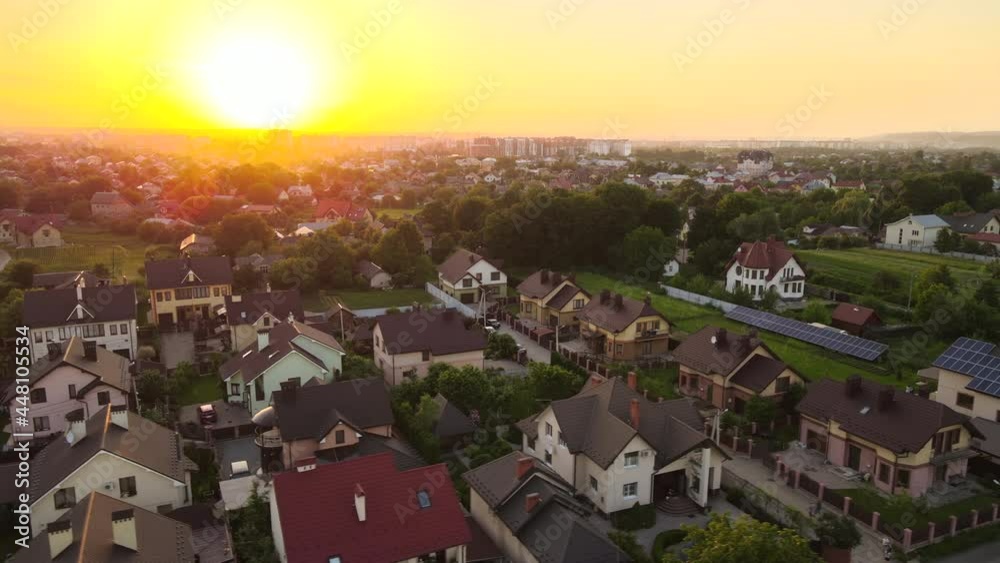 Aerial view of residential houses in suburban rural area at sunset.

