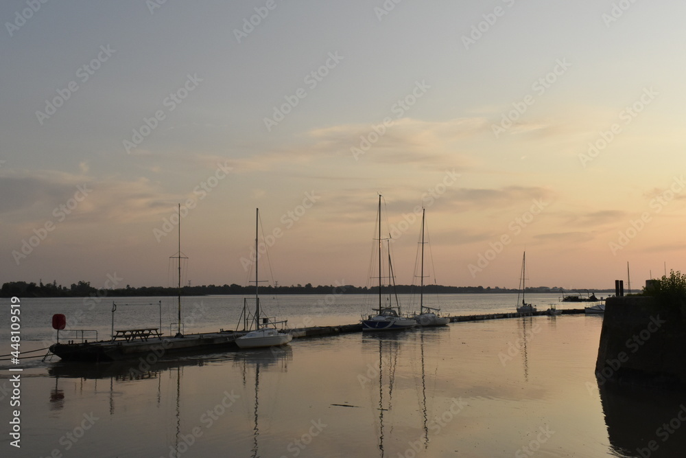 Bateaux à voile le long du ponton, au coucher du soleil, à Bourg