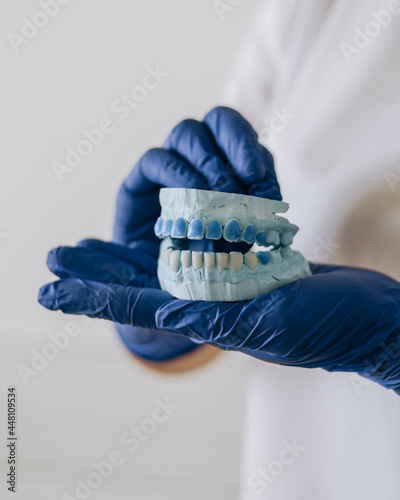 Close-up of a blue teeth dental impression on , dental technics concept in the hand of the dentist