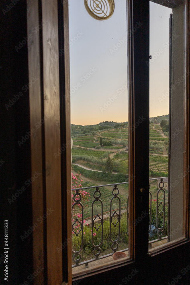 Fototapeta premium Ausblick aus einem Holzfenster in der Toscana in die Weinberge