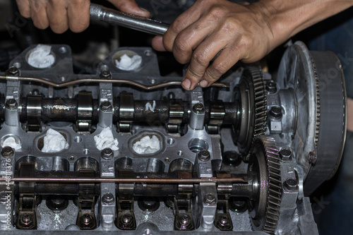 The mechanic is checking the engine.