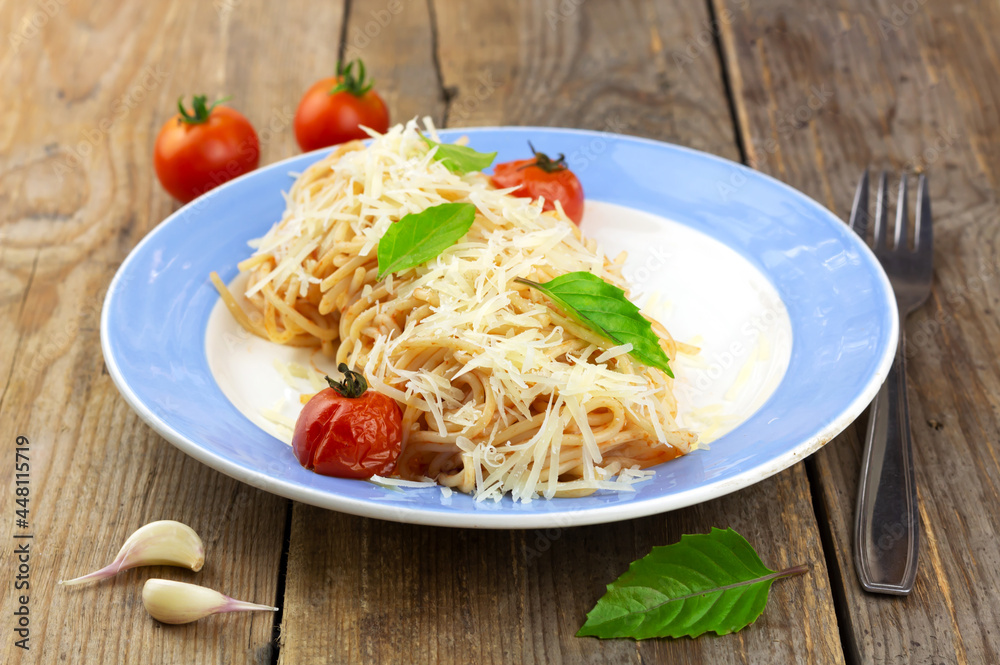 Pasta with tomato sause, cherry tomatoes and basil on wooden background