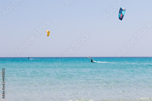 July 23, 2021: boys practicing kitesurfing in the crystal sea near the beach of La Cinta, Sardinia