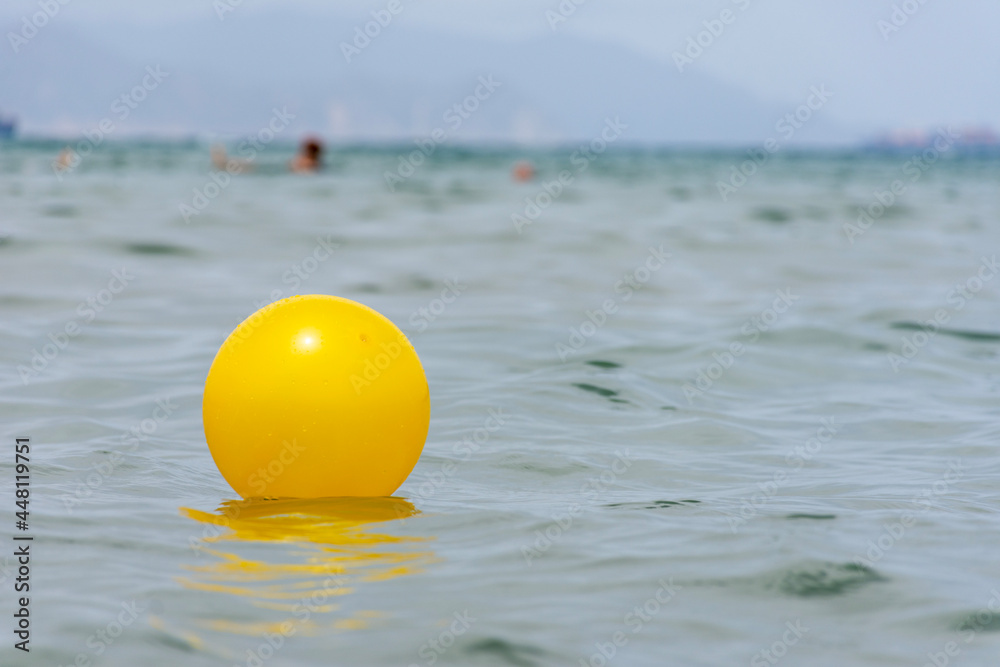 Close up of yellow beach ball floating on the water. Close up of yellow beach ball floating on the water.