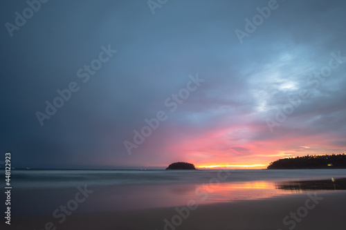 beautiful sunset behind Pu island at Kata beach Phuket. a lot of tourists relax on the beach during sunset..