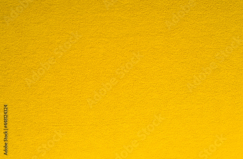 Dark yellow background made of fabric with small pile.