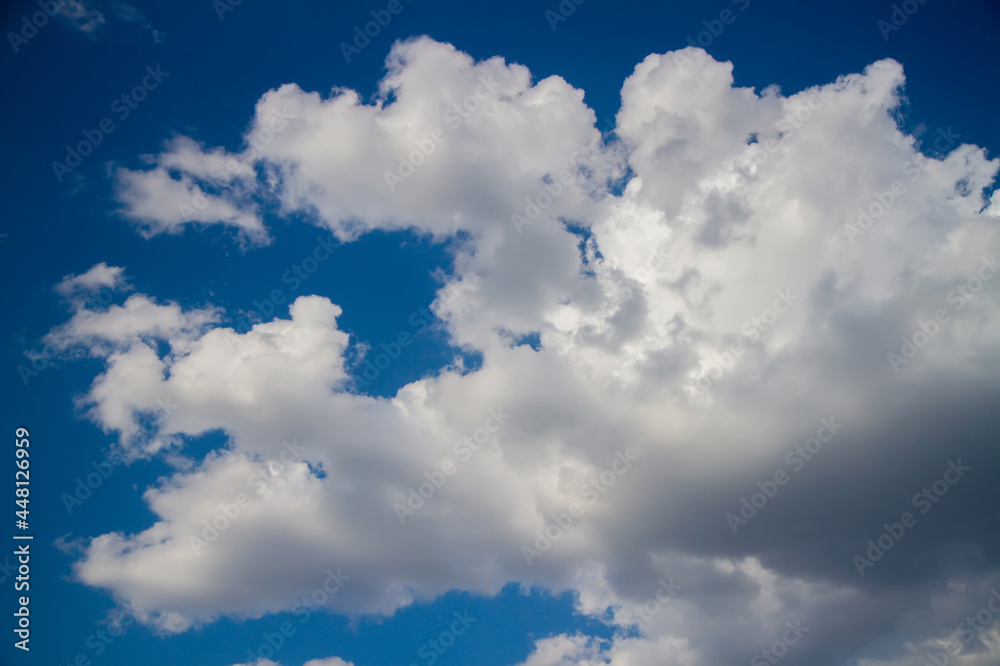 Fototapeta premium Cumulus clouds against a dark blue sky.