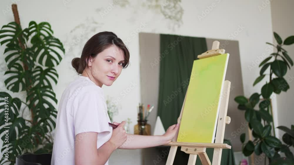 A young artist paints an abstract picture in a creative studio A young artist paints an abstract picture in a creative studio