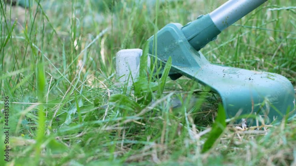 Worker in a gas mower in his hands, mowing grass in front of the house a trimmer in the hands of a man.
Worker in a gas mower in his hands, mowing grass in front of the house a trimmer in the hands of a man.