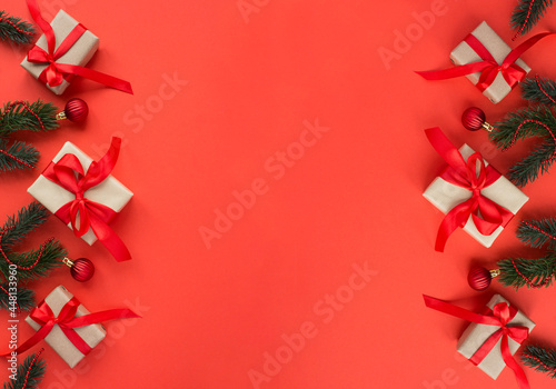 Christmas gifts with tiew red bow on the red background. Copy space.