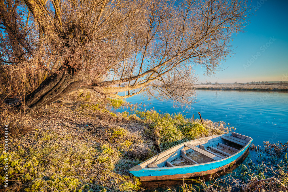 River and old wooden rowing fishing boat at beautiful sunrise in autumn morning. River and old wooden rowing fishing boat at beautiful sunrise in autumn morning.