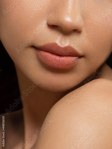 Sexual full lips. Natural gloss of lips and woman's skin. The mouth is closed. Increase in lips, cosmetology. Natural lips. Pink lip gloss