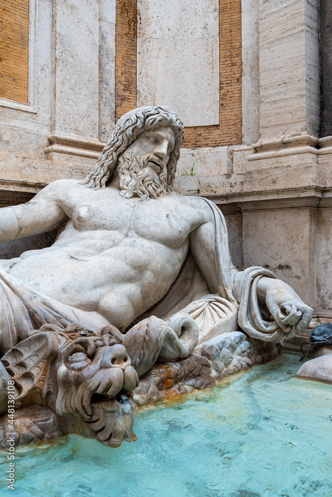 View of fountain decorated with a marble statue of Neptune resting on a divan