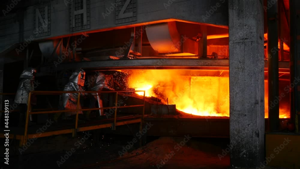 Trabalho árduo em uma fundição. Forno de fusão de metal em usina siderúrgica. Vazamento de metal fundido, metalurgia, fundição de aço. Fabricação de aço