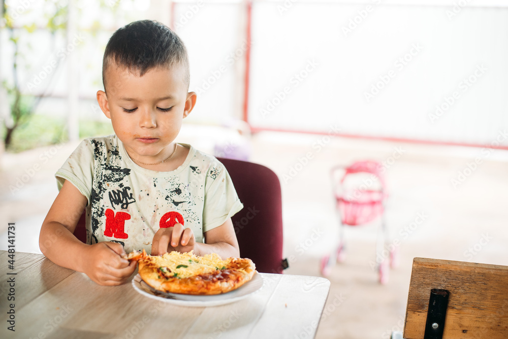 A boy, a child on the street eats a mini pizza very appetizing A boy, a child on the street eats a mini pizza very appetizing
