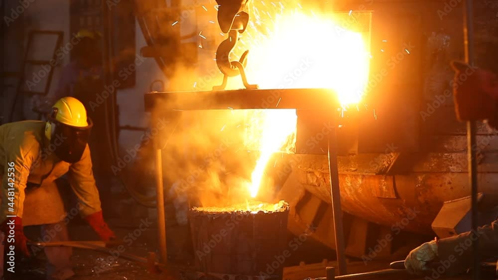 Trabalho árduo em uma fundição. Forno de fusão de metal em usina siderúrgica. Vazamento de metal fundido, metalurgia, fundição de aço. Fabricação de aço