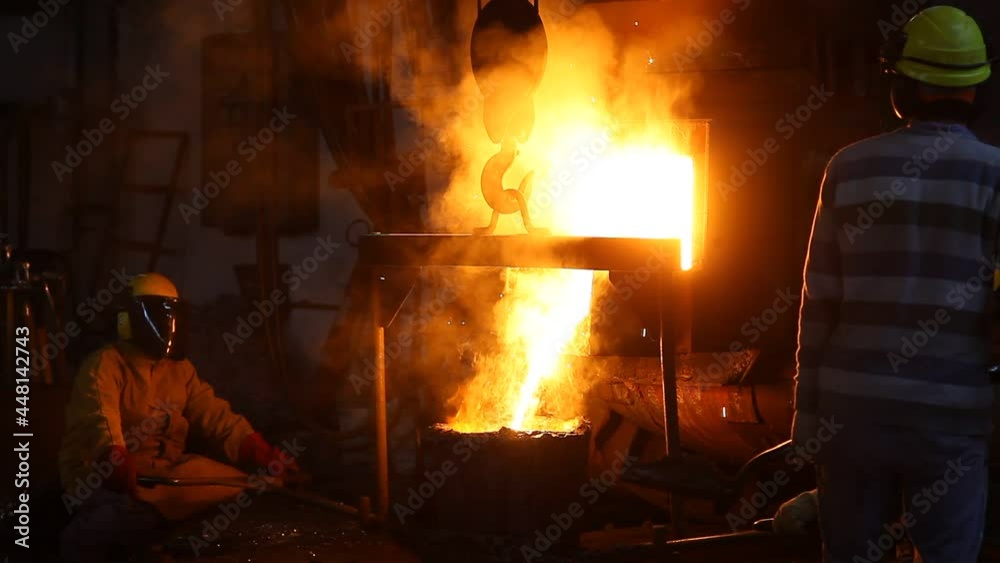 Trabalho árduo em uma fundição. Forno de fusão de metal em usina siderúrgica. Vazamento de metal fundido, metalurgia, fundição de aço. Fabricação de aço