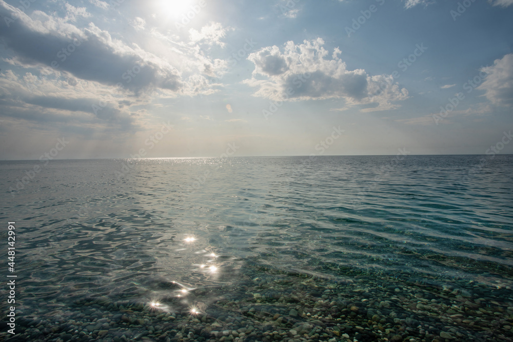 Idyllic view on silent water and sun and small clouds  - wonderful vacations on Mediterranean Sea