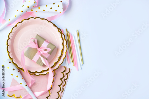 Pink tone birthday party cardboard plates  napkins  candles and present tied with silk ribbon