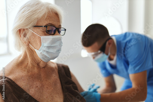 elderly woman at the hospital at the doctor's appointment covid-19 vaccination passport