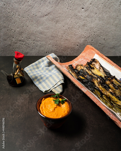 Grilled spring onions with romesco sauce and wine. Spanish cuisine photo