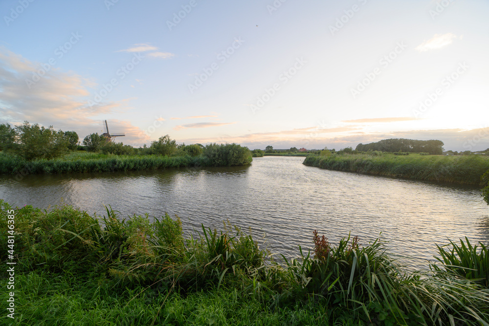 Fototapeta premium Summer landscape during sunset with the traditional dutch windmill the 't Hoog- en Groenland.