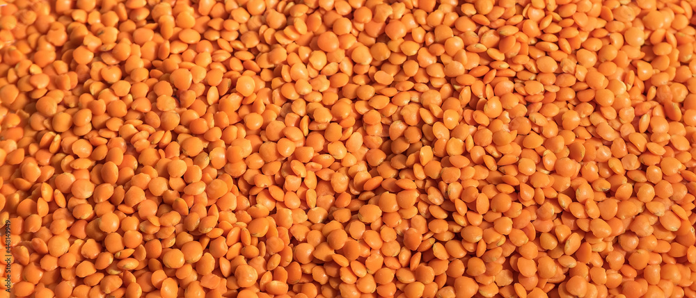 Red lentils in a wooden spoon, raw legumes Red lentils in a wooden spoon, raw legumes