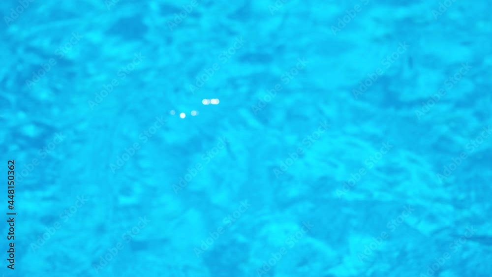 Pure transparent blue water in the swimming pool with light reflections ...