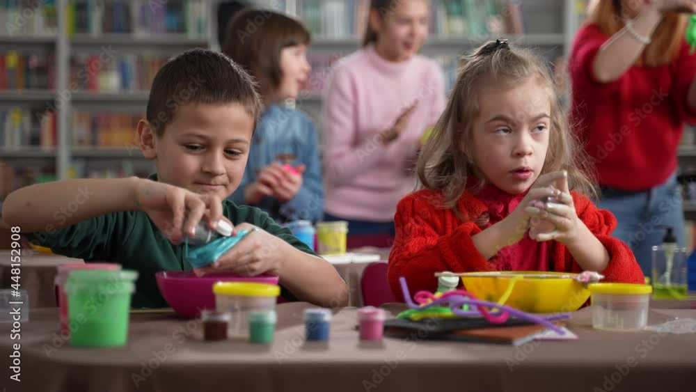 Children with different disabilities, such as autism, psychoorganic syndrome and cerebral palsy, spending time with kids, teen and preteen boys and girls making slimes during master class Children with different disabilities, such as autism, psychoorganic syndrome and cerebral palsy, spending time with kids, teen and preteen boys and girls making slimes during master class