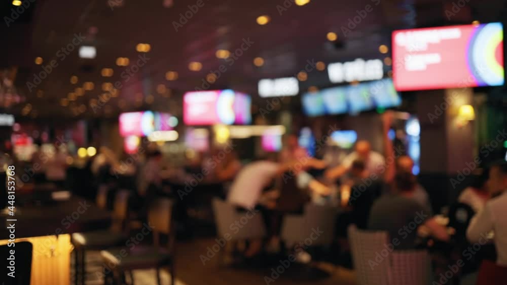 Defocused group of people handing over answers during a bar quiz game at pub Defocused group of people handing over answers during a bar quiz game at pub