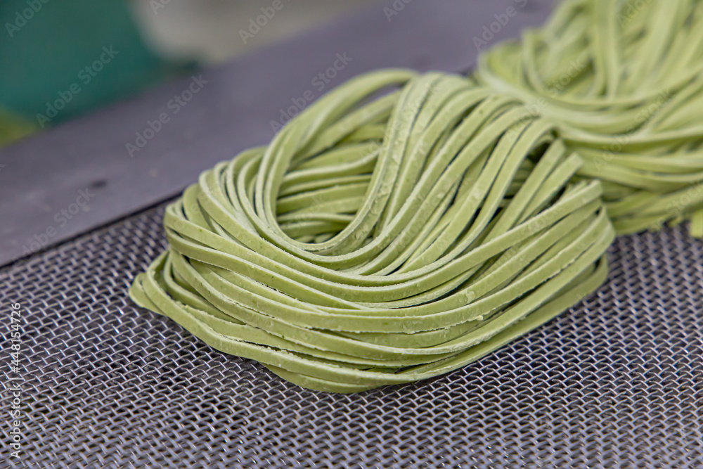 Production of noodles in an Italian restaurant. Green noodles