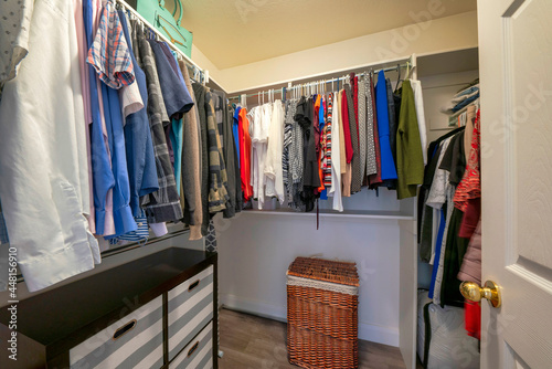 Walk in closet with an open wardrobe with metal rods
