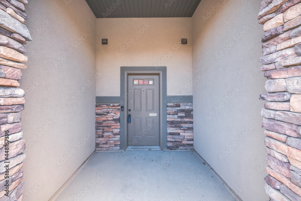 Front door exterior with brown stone bricks and concrete doorsteps
