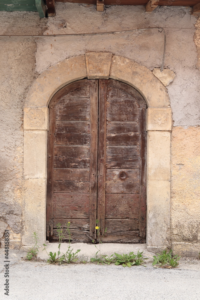 Old Wooden Door with Stone Arch and Sculpted Details in Central Italy Village
