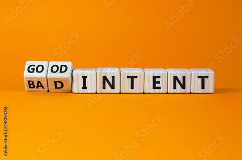 Good or bad intent symbol. Turned wooden cubes, changed words 'bad intent' to 'good intent'. Beautiful orange table, orange background. Business, bad or good intent concept. Copy space.