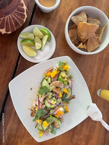 Ceviche caribeño con camarón, piña, coco, mango, pepino, cilantro, cebolla, limón, sal y pimienta