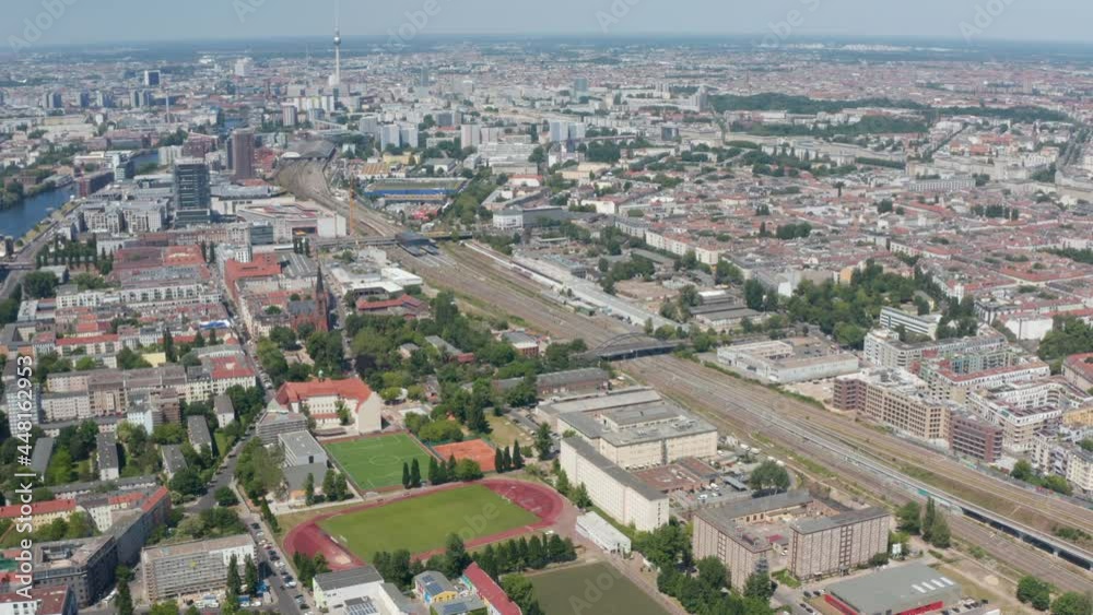 Tilt up reveal cityscape. Aerial view of large city, multitrack railway line running through urban neighbourhood. Berlin, Germany Tilt up reveal cityscape. Aerial view of large city, multitrack railway line running through urban neighbourhood. Berlin, Germany