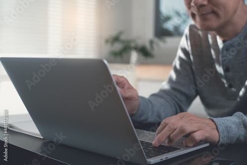 Casual business man online working on laptop computer from home office