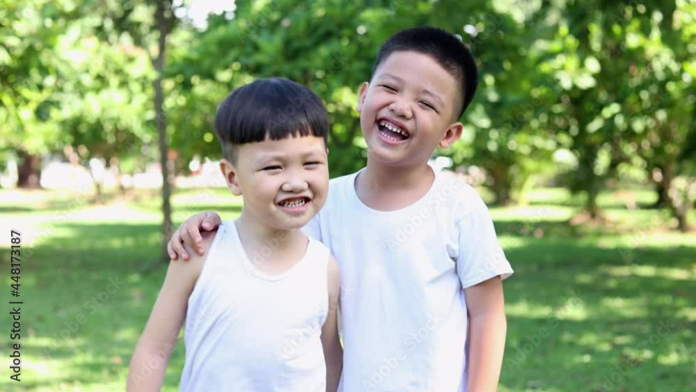 Happy two Asian boys dressed in white in the park Happy two Asian boys dressed in white in the park