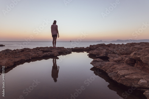 Young man watching the Sunset in Can Marroig in Formentera, Spain photo