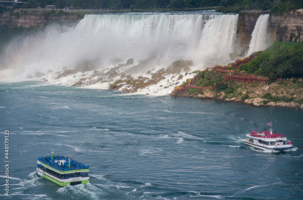 Fototapeta premium Sightseeing tour boats are shown next to the American Falls as seen from Niagara Falls, Ontario, Canada.