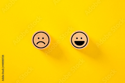 Customer choose smiley face and sad face icon on wood cube.