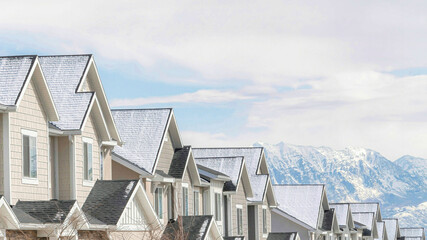 Pano Gabled townhouses with scenic mountain and overcast sky background in winter