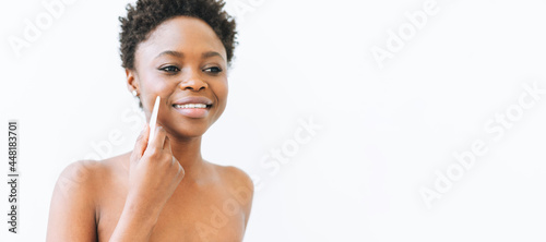 Beauty portrait of beautiful young African American woman with stone rose quartz scaper in hands near face isolated on white background, banner photo