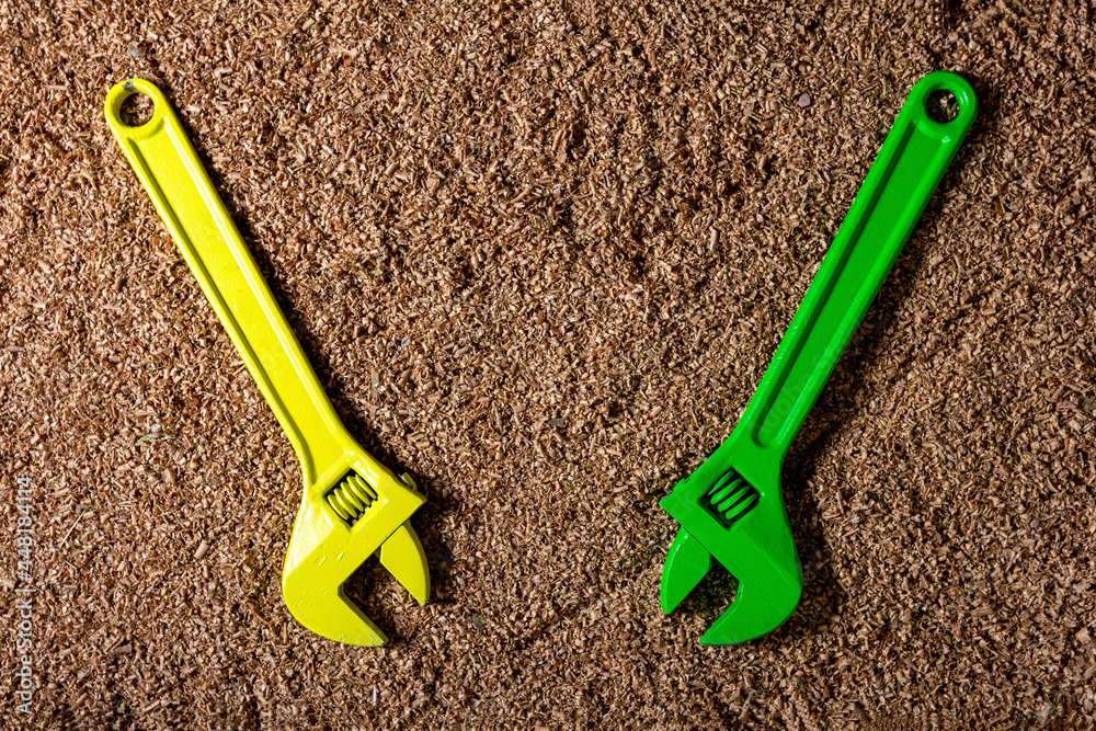 Universal wrench, for repair and installation work, against the background of a cork wood chipboard with creative coloring.