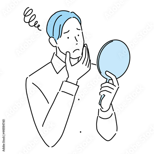 Young man worried looking in the mirror