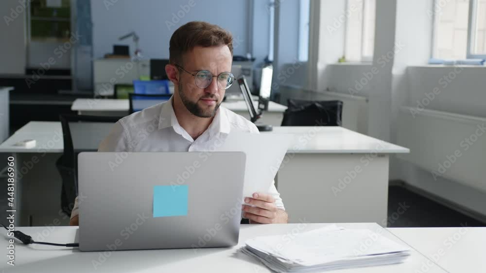 Man looks on the white papersheets Man looks on the white papersheets