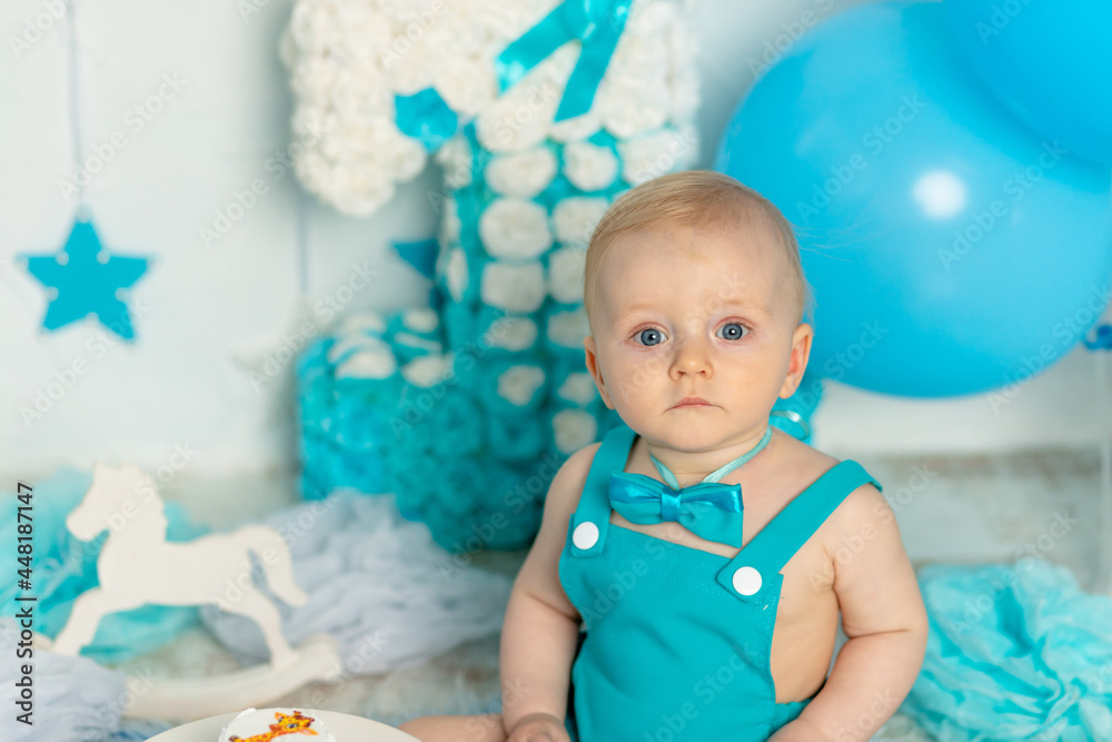 portrait of baby boy in birthday party decor one year old in blue with balloons, holiday and decor concept portrait of baby boy in birthday party decor one year old in blue with balloons, holiday and decor concept