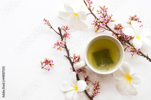 herbal healthy drinks hot green tea for health care with flowers frangipani arrangement flat lay style on background wooden white
